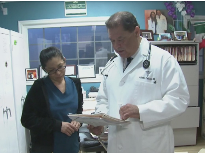 A doctor and a person in a room
Description automatically generated